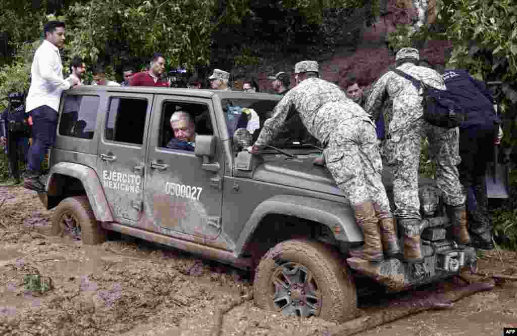 Mexican President Andres Manuel Lopez Obrador looks out of the window as the vehicle transporting him is stuck in mud during a visit to the Kilometro 42 community, near Acapulco, Guerrero State, after the passage of Hurricane Otis, Oct. 25, 2023.