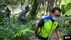Immigration officers inspect a river near the immigration detention center in Bidor in Malaysia's northern Perak state on Feb. 2, 2024, after more than 100 Rohingya refugees escaped the facility.