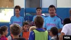 Kevin Chin (kanan belakang) dan Patricia Tomanon (kiri belakang) melatih para pemain muda dari usia lima tahun di pusat latihan pesepak bola Trekkerz Performance Training di Florida Selatan (VOA Indonesia)