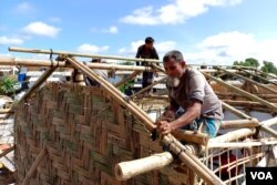 Two Rohingya men build a house inside Jamtoli refugee camp, Cox’s Bazar, Bangladesh, on Aug. 28, 2023. The refugees live in flimsy bamboo and plastic sheet shanties. (Noor Hossain for VOA)