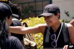 Actor Rosario Dawson attends a rally by striking writers and actors outside Warner Bros. studios in Burbank, Calif., July 14, 2023.