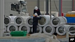 FILE - Workers check on the material for the Dongfeng truck at a manufacturing factory in Shiyan city in central China's Hubei Province on May 12, 2023. China's factory activity contracted in July, a survey showed on July 31, 2023.