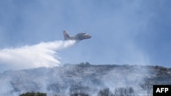 A canadair drop water onto a wildfire near the city of Volos, central Greece, on July 27, 2023. 