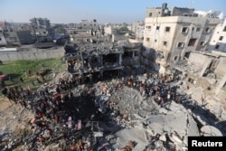 Palestinians gather at the site of an Israeli strike on a house, amid the ongoing conflict between Israel and the Palestinian Islamist group Hamas, in Rafah, in the southern Gaza Strip, Dec. 19, 2023.