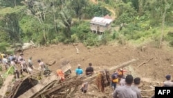 Tim penyelamat mencari orang hilang di lokasi longsor yang menewaskan sedikitnya 18 orang dan menyebabkan dua orang hilang di Tana Toraja, Sulawesi Selatan. (Handout / Badan Pencarian dan Pertolongan Nasional (BASARNAS) / AFP) 