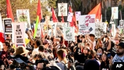 Demonstrators hold signs as they march in opposition to the APEC Summit, in San Francisco, California, Nov. 12, 2023.