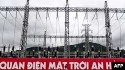 A security guard walks past the substation at Sao Mai solar energy plant in An Giang province, Vietnam, Sept. 25, 2022.