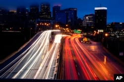 In this image made with a long exposure, motor vehicles move along Interstate 76 ahead of the Thanksgiving Day holiday in Philadelphia, Nov. 22, 2023.