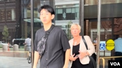 FILE - Xiaolei Wu, who was indicted on charges of stalking and threatening a pro-democracy activist at his college in Boston, walks out of a federal court in Boston with his lawyer, Jessica Hedges, after a pre-trial conference, July 27, 2023. (Hai Lun/VOA)