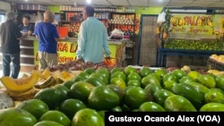 Clientes se aprestan para pagar sus compras de comida en una venta de frutas, vegetales y víveres en Maracaibo, Venezuela, el 13 de julio de 2023. Expertos hablan hoy de una recesión.