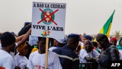 Un manifestatant tient une pancarte sur laquelle on peut lire "à bas la CEDEAO, vive l'ASS" lors d'un rassemblement pour célébrer le départ du Mali, du Burkina Faso et du Niger de la CEDEAO, à Bamako, le 1er février 2024. (Photo OUSMANE MAKAVELI / AFP)