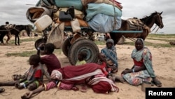 Sudanese family who fled the conflict in Murnei in Sudan's Darfur region, sit beside their belongings while waiting to be registered by UNHCR upon crossing the border between Sudan and Chad in Adre, Chad, July 26 , 2023.