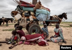 FILE - Sudanese family who fled the conflict in Murnei in Sudan's Darfur region, sit beside their belongings while waiting to be registered by UNHCR upon crossing the border between Sudan and Chad in Adre, Chad, July 26 , 2023.
