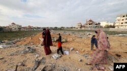 Palestinians inspect the destruction in Rafah on Feb. 18, 2024, following overnight Israeli air strikes on the southern Gaza Strip border city.