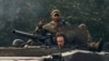 FILE - A Ukrainian soldier shows a V-sign atop a vehicle in Izium, Kharkiv region, Ukraine, Sept. 13, 2022. 