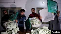FILE - Election workers empty ballot boxes after polls closed at a station during the general election in Lahore, Pakistan, Feb. 8, 2024. No single party succeeded in winning a simple majority in the National Assembly.