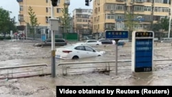 Hujan deras di distrik Mentougou, Beijing, China, memicu banjir dan menghanyutkan mobil-mobil di jalanan, 31 Juli 2023.
