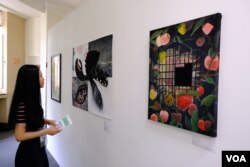 参展者“煲儿”其中一幅显示被封禁的苹果，但在铁闸以后，却生出不少新的苹果 (美国之音/郑乐捷)