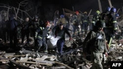 Ukrainian police officers and rescuers carry the body of a local resident killed in a Russian rocket attack in Kramatorsk, Donetsk region, on Feb. 17, 2024.