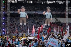 Balon calon Presiden Prabowo Subianto, kiri, dan pasangannya Gibran Rakabuming Raka, putra sulung Presiden Joko Widodo, dipajang saat kampanye di Stadion Utama Gelora Bung Karno di Jakarta, 10 Februari 2024. (Foto: AP)