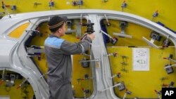 A worker examines a car frame at a Vinfast factory in Hai Phong, Vietnam on Sept. 29, 2023.