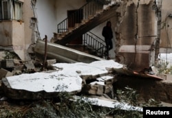 A Palestinian man walks in a damaged building after Israeli forces raided Jenin refugee camp in the Israeli-occupied West Bank, Nov. 19, 2023.