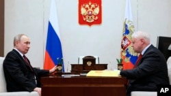 FILE - Russian President Vladimir Putin, left, listens to Sergey Mironov, the leader of political party A Just Russia in Moscow, on Feb. 14, 2023. (Mikhail Metzel, Sputnik, Kremlin Pool Photo via AP)