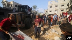 Palestinians pull a boy from the rubble after an Israeli strike on the Zaroub family house in Rafah, Gaza Strip, Oct. 24, 2023.