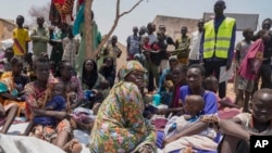 FILE - South Sudanese who fled from Sudan sit outside a nutrition clinic at a transit center in Renk, South Sudan, May 16, 2023.