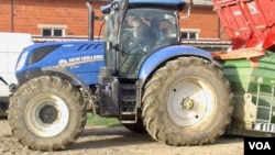 Jerome Regnault sits in his tractor at his farm in Plaisir, France. (Lisa Bryant/VOA)
