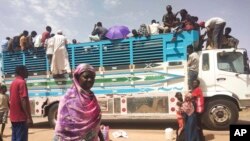 FILE - People board a truck as they leave Khartoum, Sudan, on June 19, 2023.