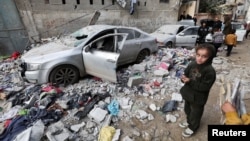 Palestinians inspect damaged vehicles at the site of an Israeli strike in Rafah in the southern Gaza Strip, Feb. 9, 2024.
