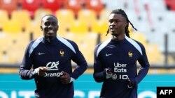 O médio francês Eduardo Camavinga (dir) e o defesa francês Ferland Mendy treinam para jogo de preparação do Euro 2024