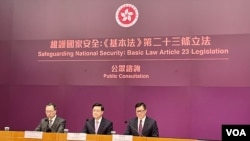 香港特首李家超（中）率領律政司司長林定國（左）及保安局局長鄧炳強召開記者會，正式宣布展開為期29日的《基本法》23條立法公眾諮詢。(美國之音/湯惠芸)
