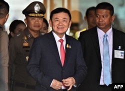 FILE -- Former Thai Prime Minister Thaksin Shinawatra, center, arrives to greet his supporters after landing at Don Mueang Airport in Bangkok, Aug. 22, 2023.