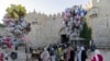 Umat Islam berjalan melewati Gerbang Damaskus di luar Kota Tua Yerusalem untuk mengikuti salat Iduladha di kompleks Masjid Al Aqsa, Rabu, 28 Juni 2023. (AP/Ohad Zwigenberg)