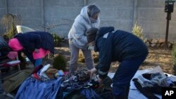 People gather their belongings from the building which was destroyed as a result of Russian strike in Zaporizhzhia district, Ukraine, March 31, 2023.
