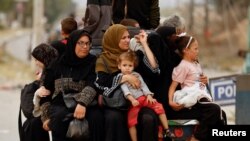 Palestinians fleeing north Gaza ride an animal-drawn cart as they move southward, as Israeli tanks roll deeper into the enclave, in the central Gaza Strip Nov. 12, 2023. 