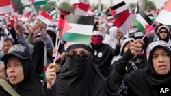 FILE - Muslim women wave Palestinian and Indonesian flags during a rally supporting the Palestinians in Jakarta, Indonesia, Oct. 15, 2023.