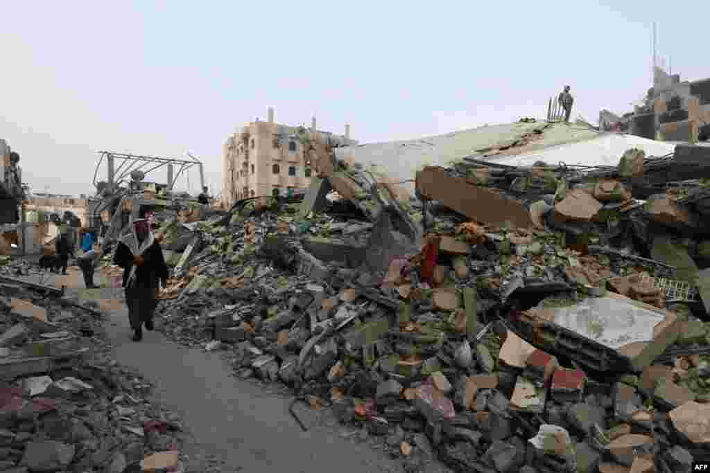 People walk near buildings leveled by Israeli bombardment in Rafah in the southern Gaza Strip, Feb. 25, 2024.