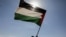 FILE - Houthi followers hold a Palestinian flag during a parade in solidarity with the Palestinians in the Gaza Strip and to show support for Houthi strikes on ships in the Red Sea and the Gulf of Aden, in Sanaa, Yemen, Jan. 29, 2024. 