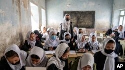 FILE - Afghan schoolgirls in their classroom on the first day of the new school year, in Kabul, March 25, 2023. 
