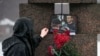 A woman touches a photo of Alexey Navalny after laying flowers at the Memorial to Victims of Political Repression in St. Petersburg, Russia, on Feb. 17, 2024.