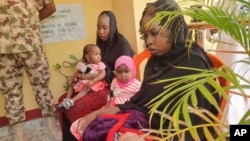 FILE - Then-recently freed Chibok schoolgirls sit with their children at the Army Maimalari Cantonment in Maiduguri, Nigeria, May 4, 2023.