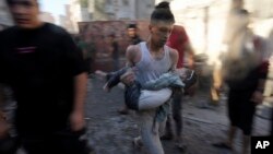 Palestinians evacuate survivors after Israeli airstrikes on buildings in Deir al Balah, Gaza Strip, Nov. 7, 2023.