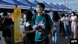 资料照：青年人正在北京的一个招聘点寻找工作。（2022年8月26日）