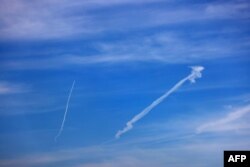 An inversion trail from a fighter bomber marks the sky over Ukrainian positions in the Donetsk region on April 13, 2024, amid the Russian invasion in Ukraine.