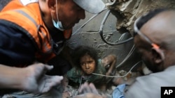 Palestinians try to pull a girl out of the rubble of a building that was destroyed by Israeli airstrikes in Jabaliya refugee camp, northern Gaza Strip, Nov. 1, 2023.