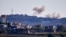 FILE - A picture taken from from the southern Lebanese village of Tayr Harfa, near the border with Israel, shows smoke from rockets fired by Hezbollah billowing near an Israeli outpost on Dec. 15, 2023. 