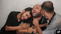 মোহাম্মদ আল-হাবিল তার চাচা আবদুল মুতি আল-হাবিলের সাথে নিহত হওয়ার পর তার বাবা আত্মীয়দের সাথে কাঁদছেন। দেইর আল বালাহ, গাজা। জুন ১৪,২০২৪। 